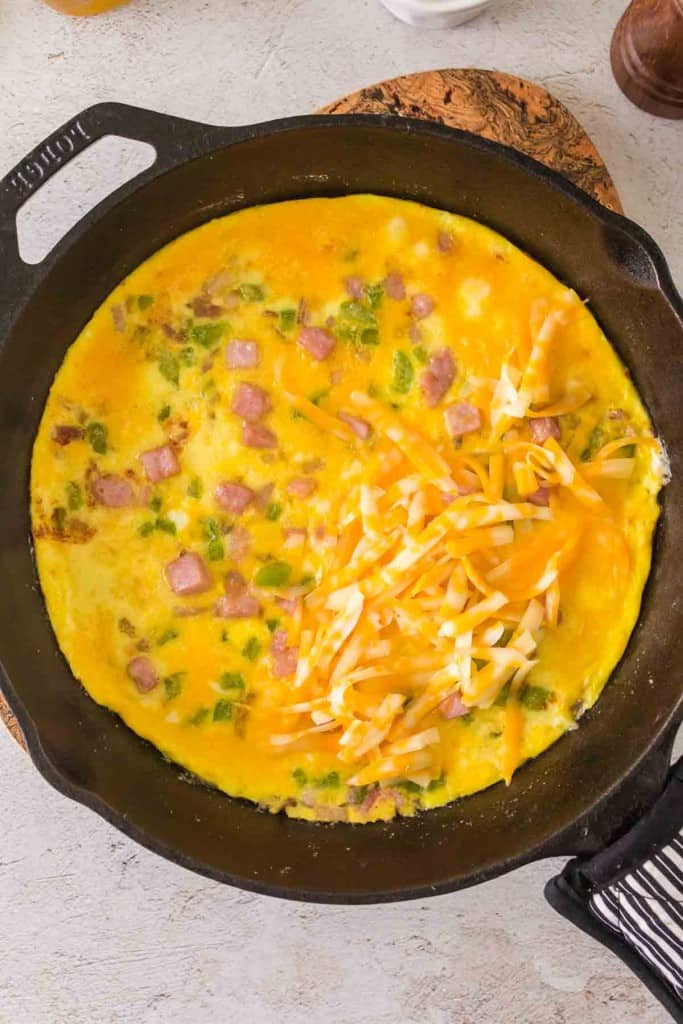 Denver omelet cooking in a skillet.