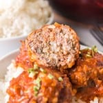 close up of porcupine meatballs with sauce over rice cut in half to reveal the inside