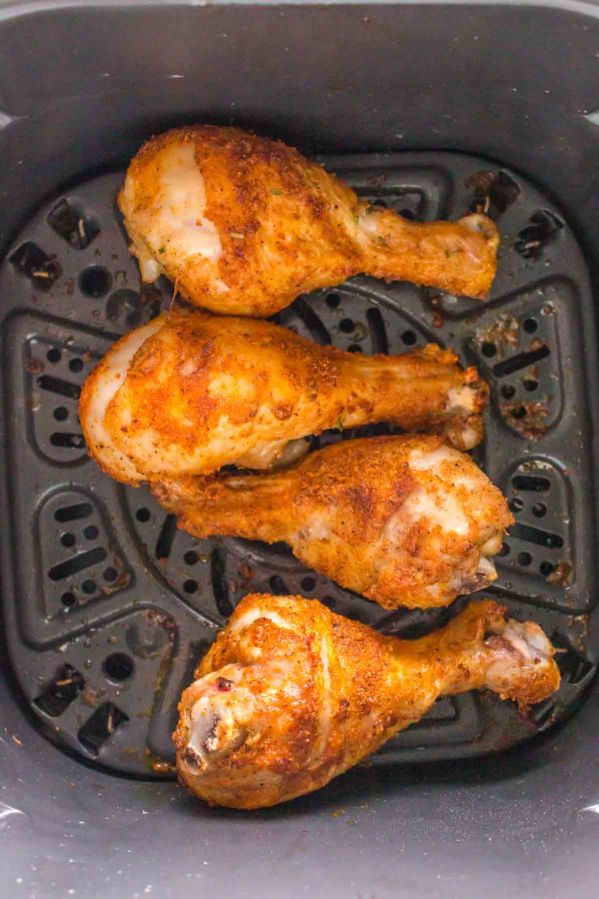 golden crisp air fried chicken drumsticks in the air fryer basket.