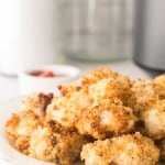 air fryer chicken nuggets on a white plate with ketchup on the side