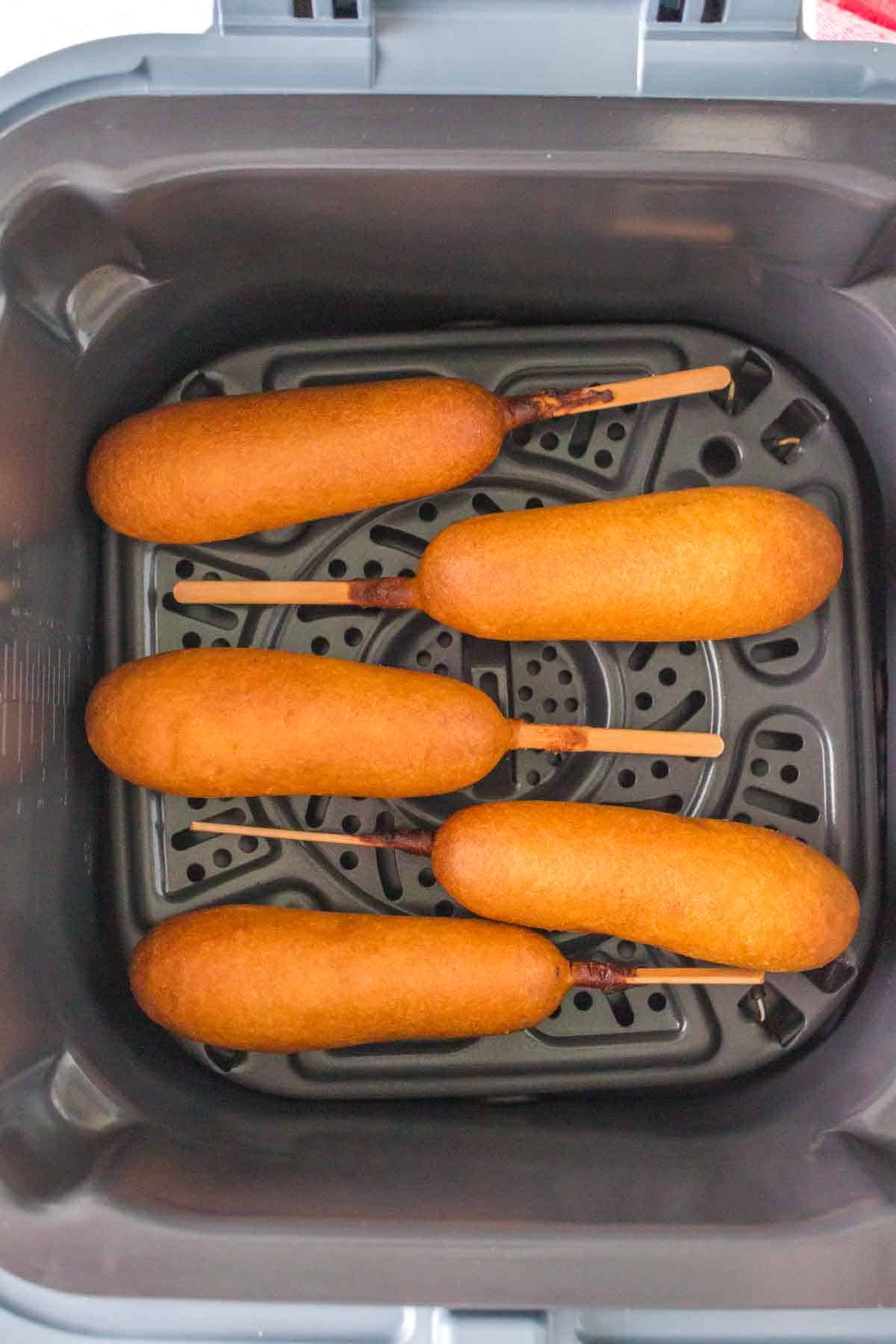 air fryer corn dogs lined up in the basket