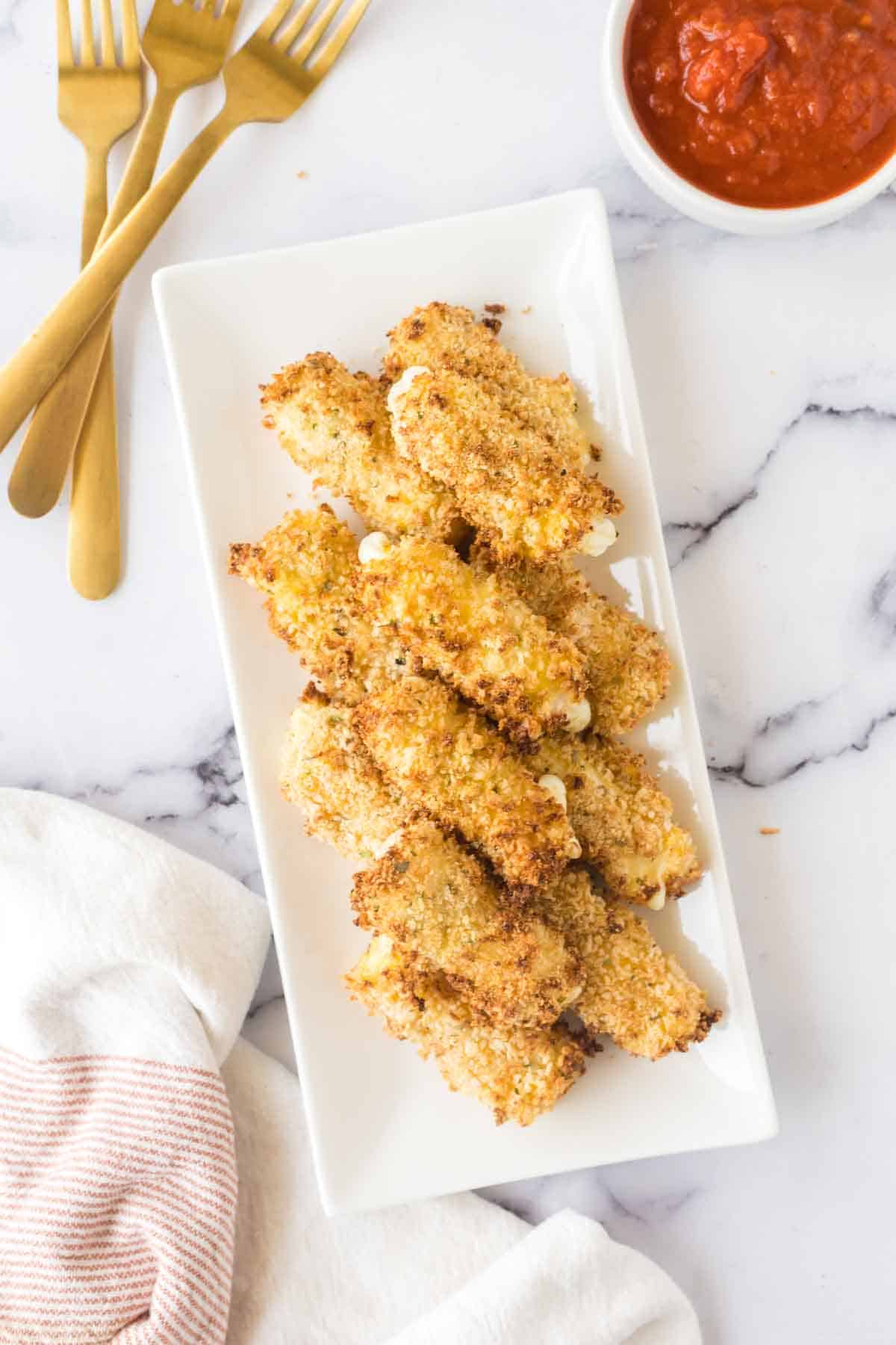 cooked row air fryer mozzarella sticks on a plate