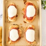 four chicken parmesan dinners on a small baking sheet