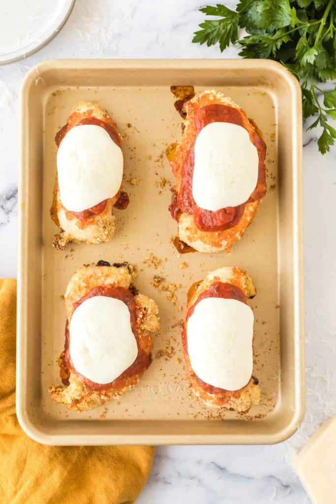 four chicken parmesan dinners on a small baking sheet