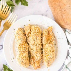 three baked chicken tenders on a white plate