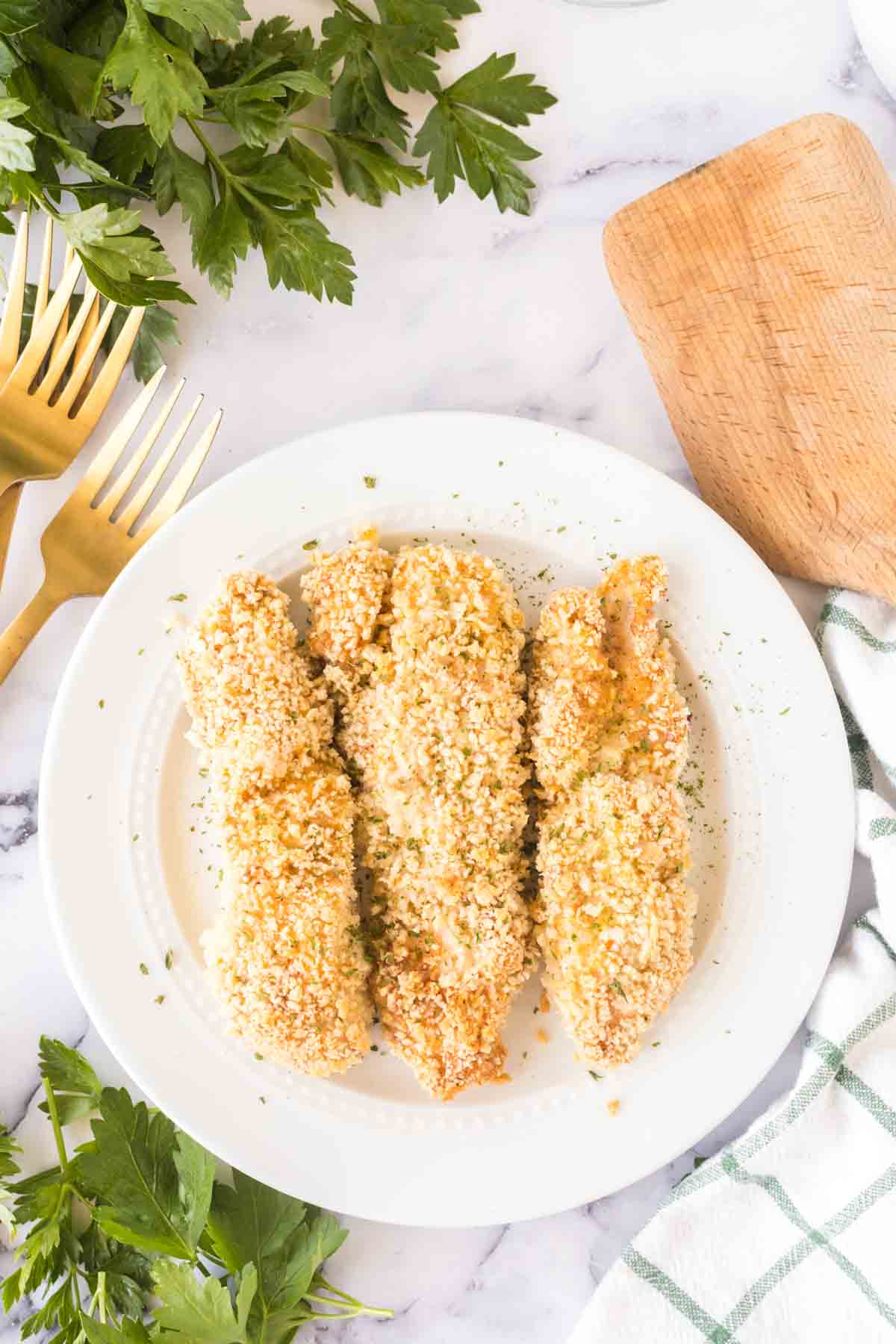 Baked chicken tenders on a white plate.