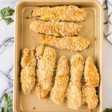 breaded chicken tenders on a baking sheet
