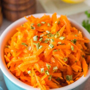 shredded carrot salad in a small blue bowl