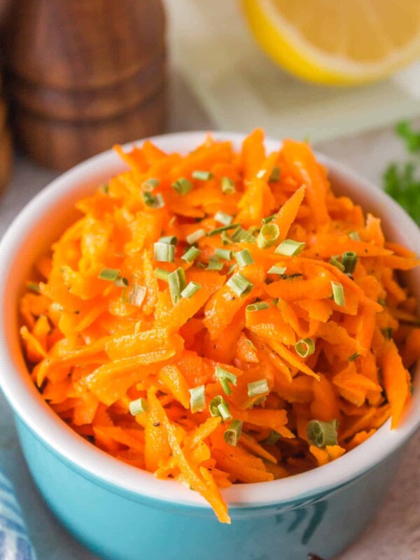 shredded carrot salad in a small blue bowl