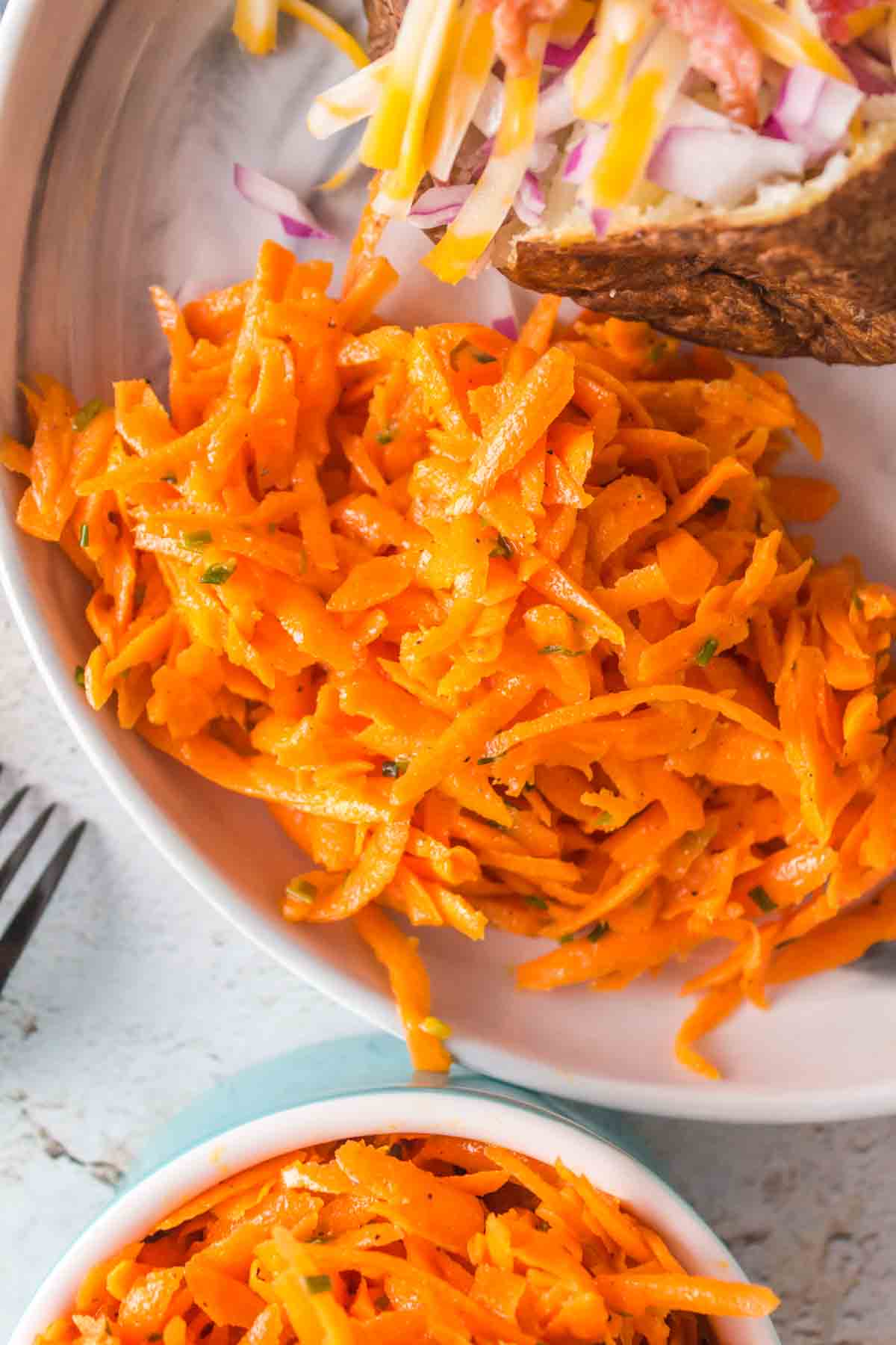 shredded carrot salad on a plate with meat