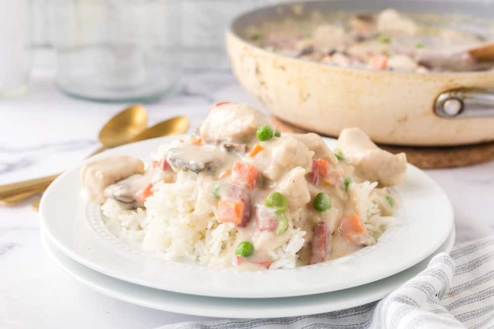 chicken ala king served onto a white plate over rice