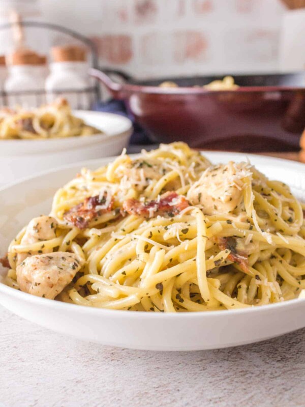chicken carbonara with bacon and cheese on a white plate