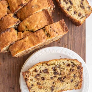 top view of chocolate chip banana bread sliced and one on a white plate