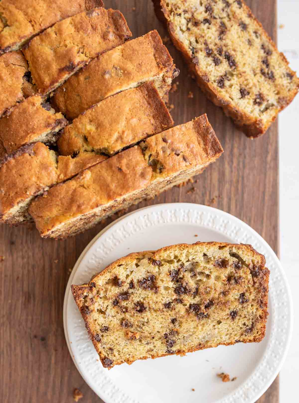 top view of chocolate chip banana bread sliced and one on a white plate