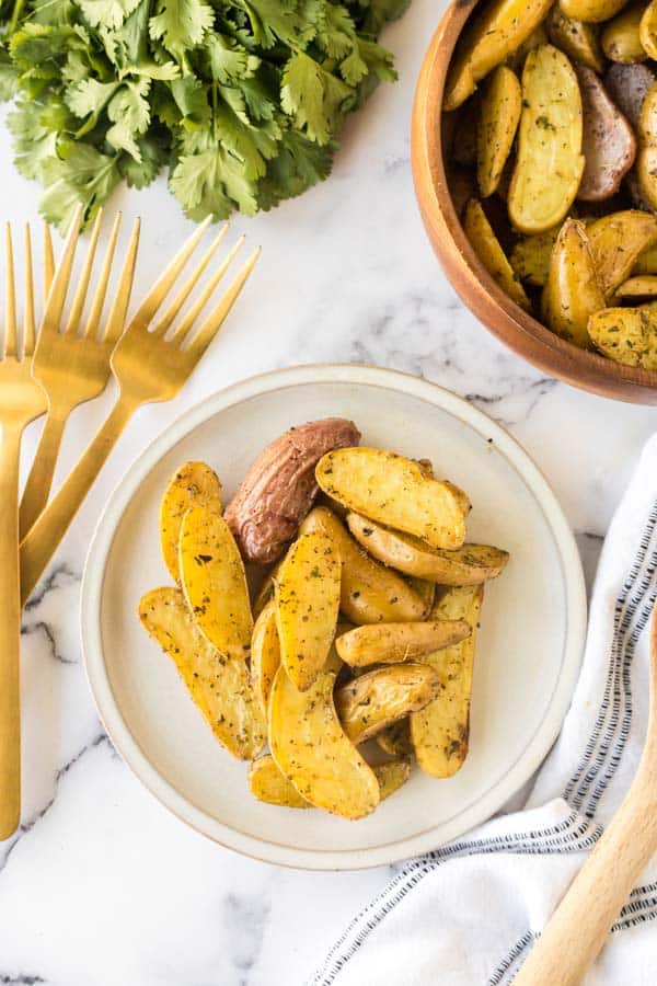 Roasted fingerling potatoes on a white plate.