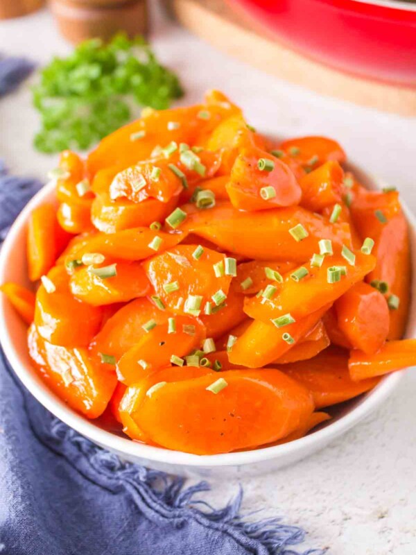 glazed carrots in a white dish with chives on top