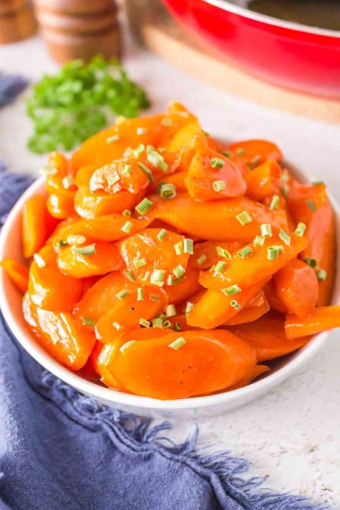 glazed carrots in a white dish with chives on top