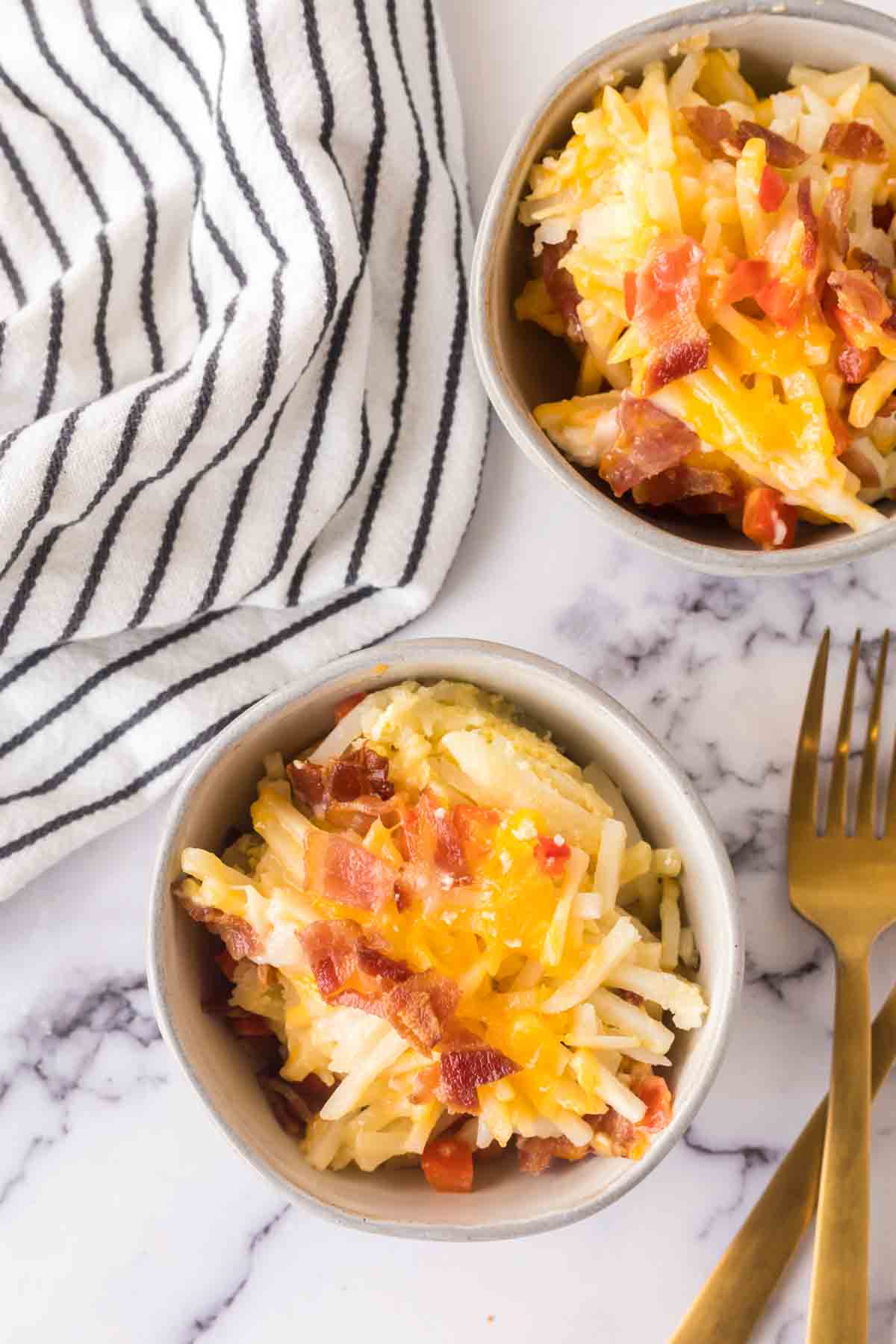 small portion dishes of the baked hash brown breakfast casserole with melted cheese and bacon on top