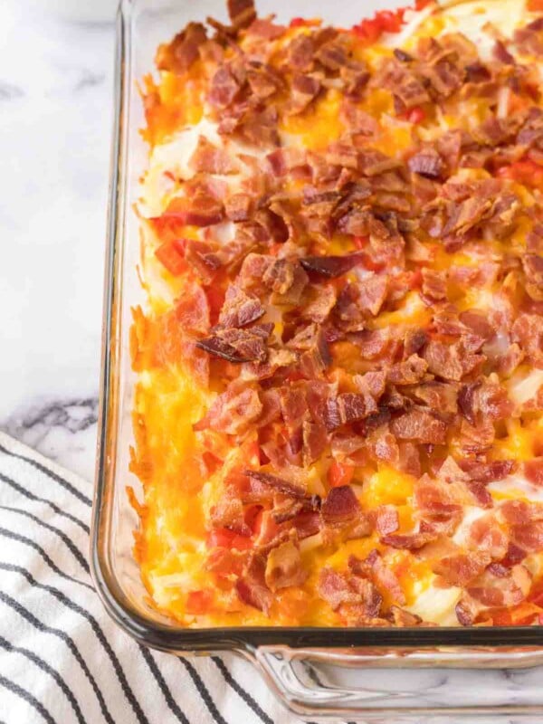 baked in a clear rectangle baking dish, hash brown breakfast casserole with melted cheese and bacon on top