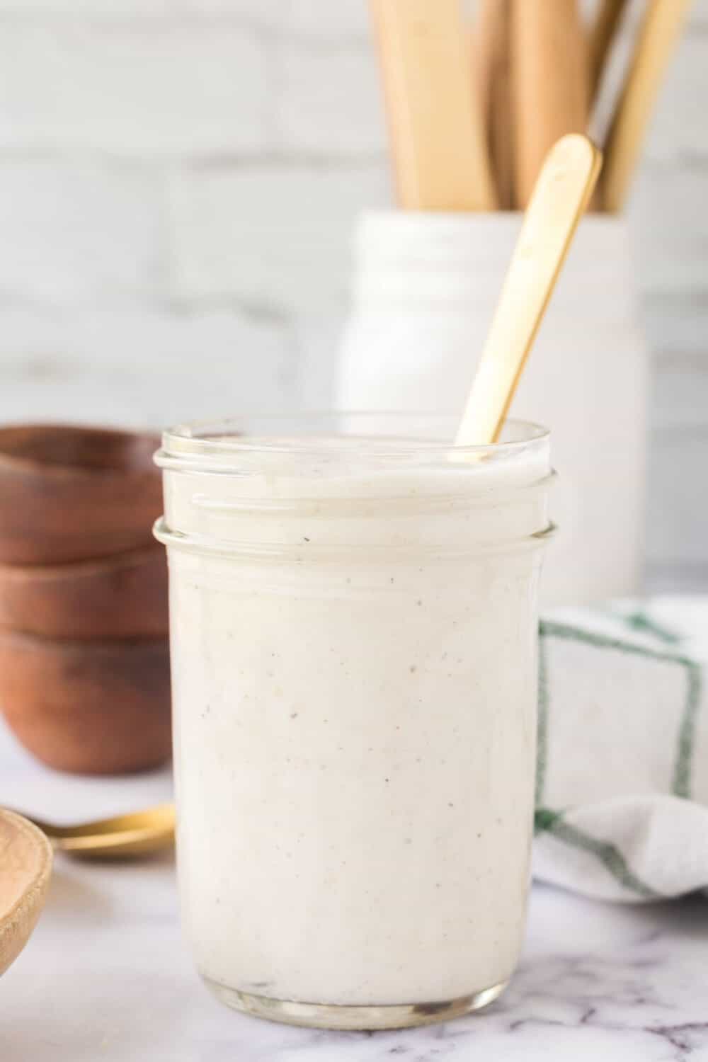 white horseradish sauce in a mason jar with a spoon