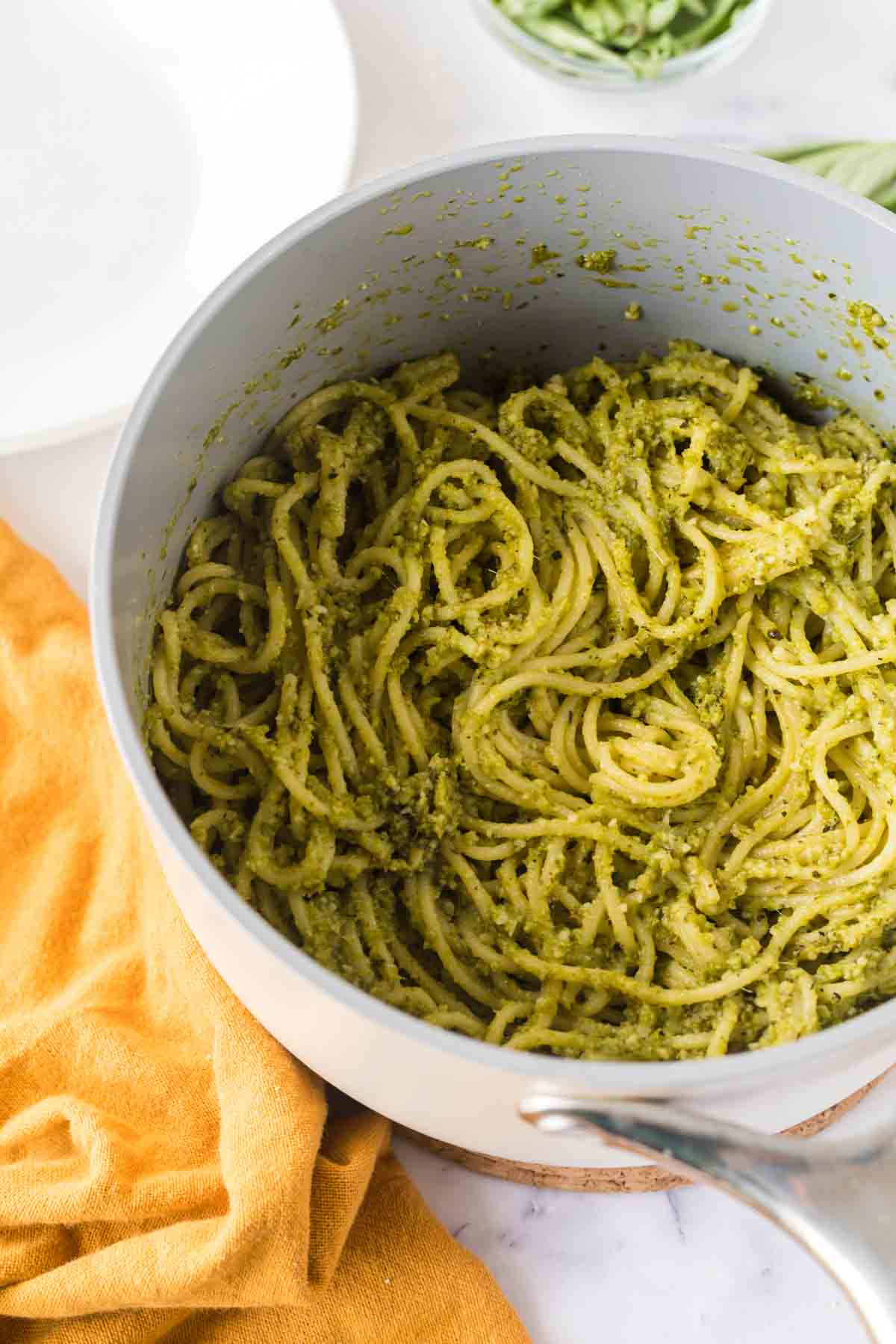 pesto over pasta in a sauce pan