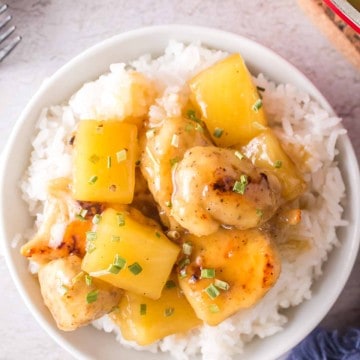 pineapple chicken served on a plate over a bed of rice