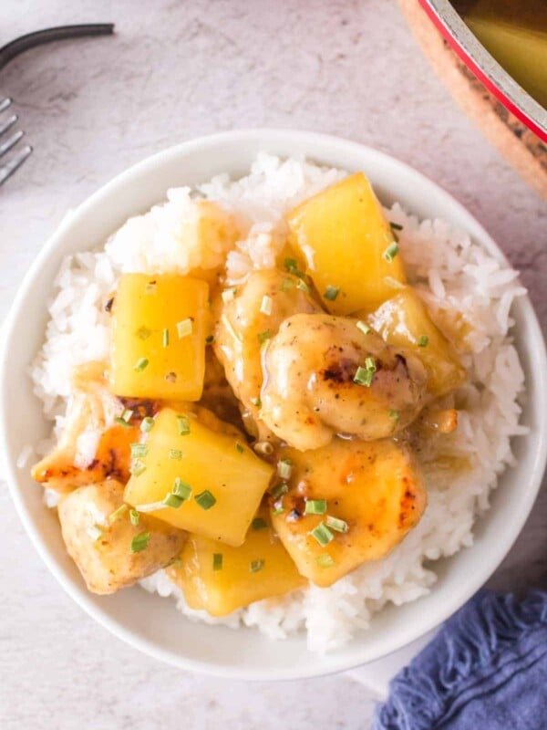 pineapple chicken served on a plate over a bed of rice