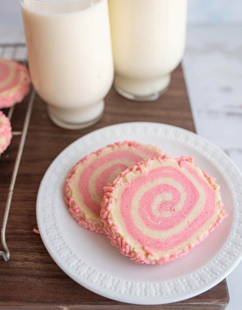 close up of a plate of pink and tan pinwheel cookies