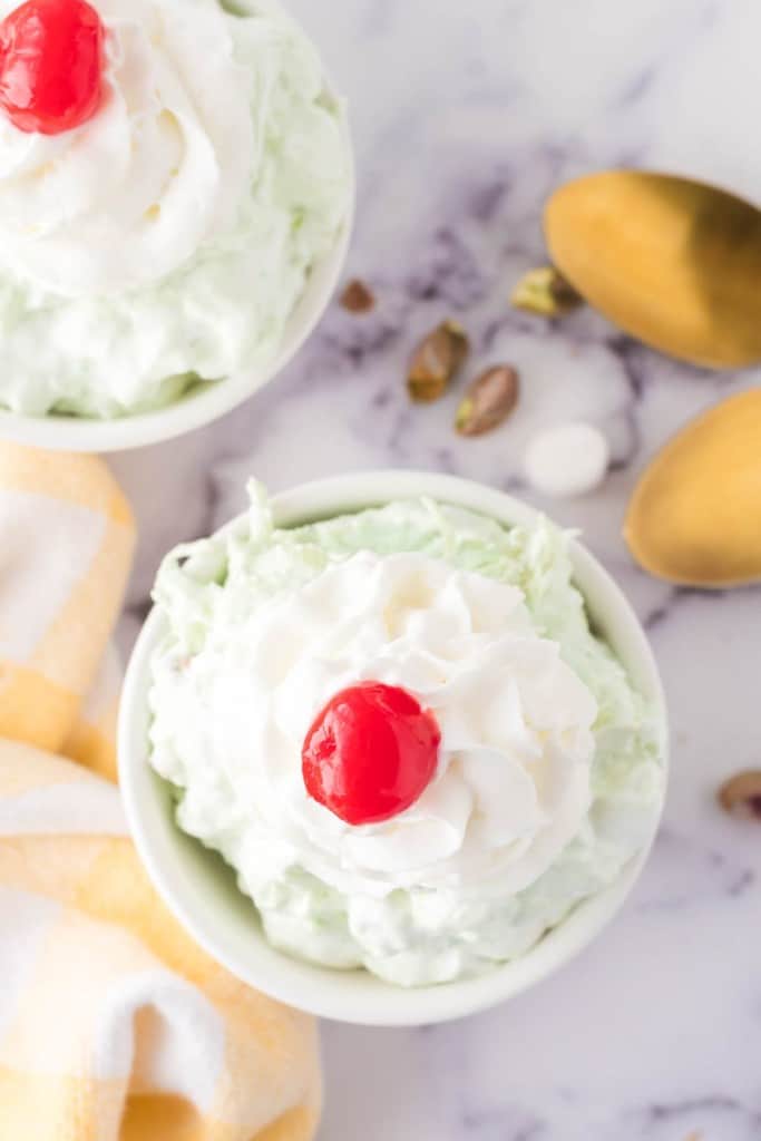 top view of pistachio jello salad topped with whipped cream and a cherry