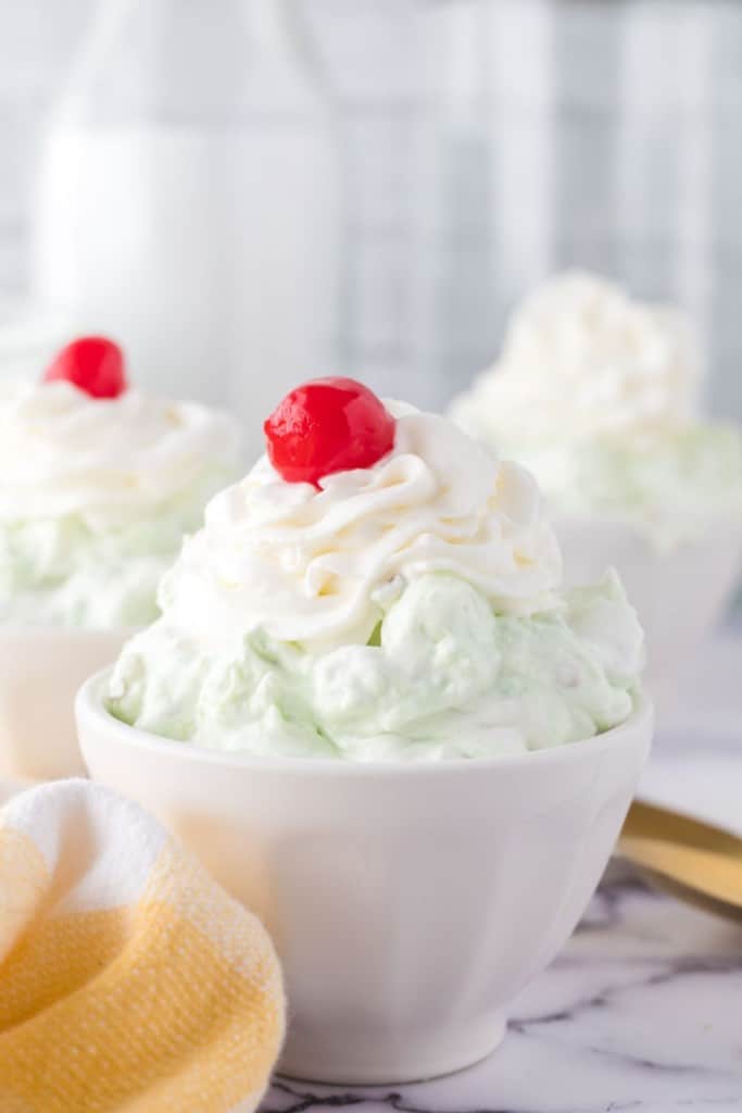 top view of pistachio jello salad topped with whipped cream and a cherry
