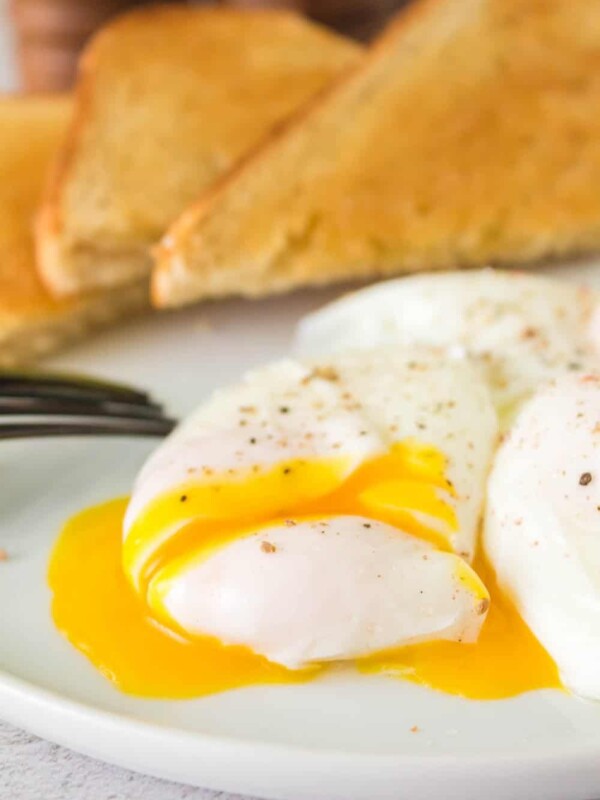 gooey poached egg on a plate and its yolk pouring out