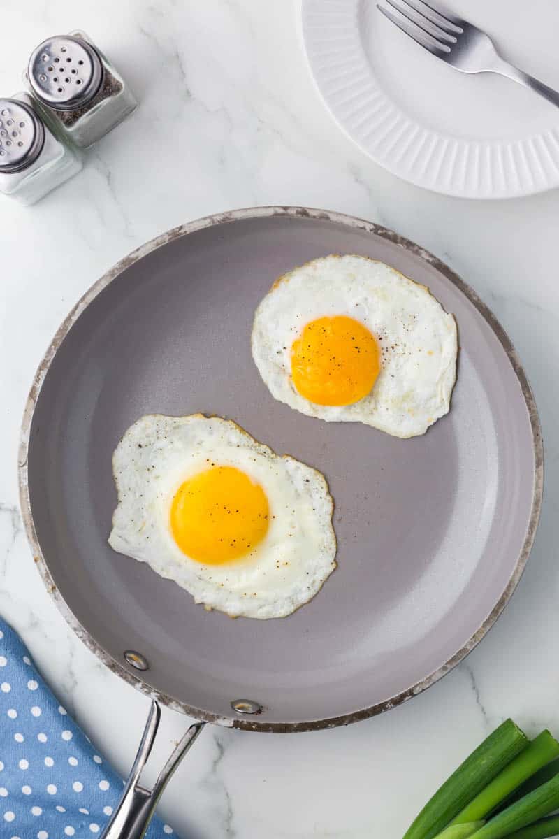 2 eggs cooking in a skillet.