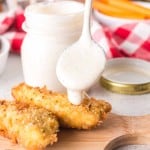 White BBQ sauce getting dripped on chicken tender