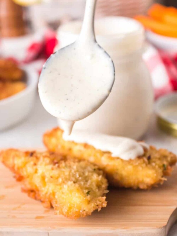 White BBQ sauce getting dripped on chicken tender