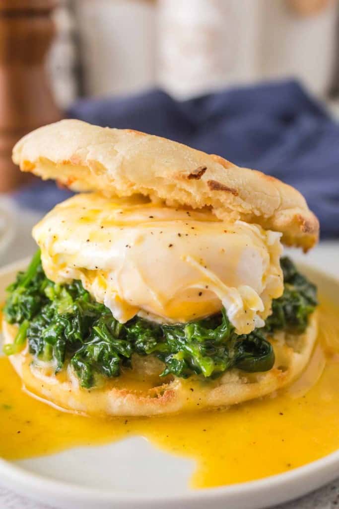 gooey poached egg atop spinach between an english muffin for eggs Florentine