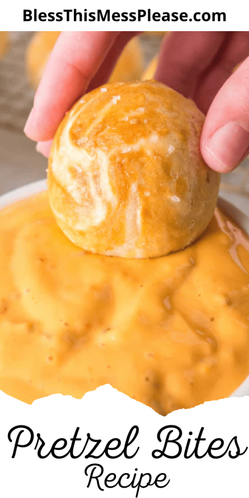 Pretzel bite being dipped in cheese sauce