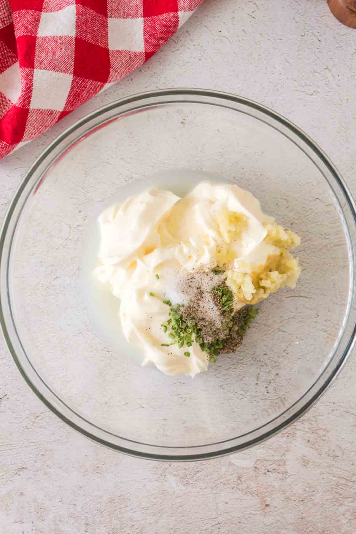 raw aioli ingredients in a clear mixing bowl