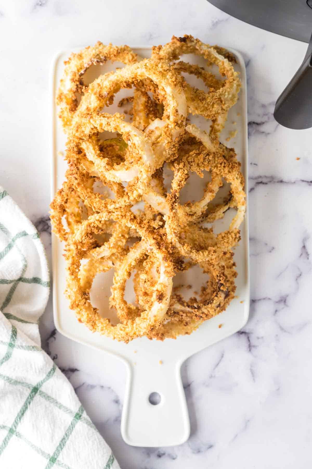 a plate of crispy golden onion rings on a dish