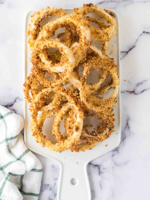 a plate of crispy golden onion rings on a dish.