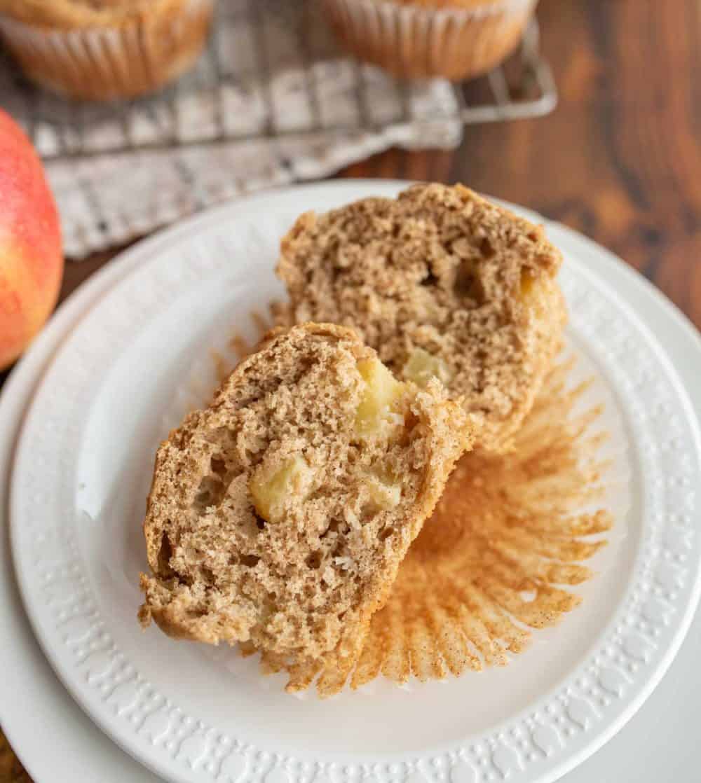 split open apple cinnamon muffins on a white plate