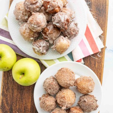 small round apple fritter bites stacked onto a plate top view