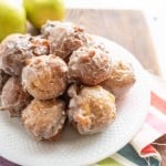 small round apple fritter bites stacked onto a plate