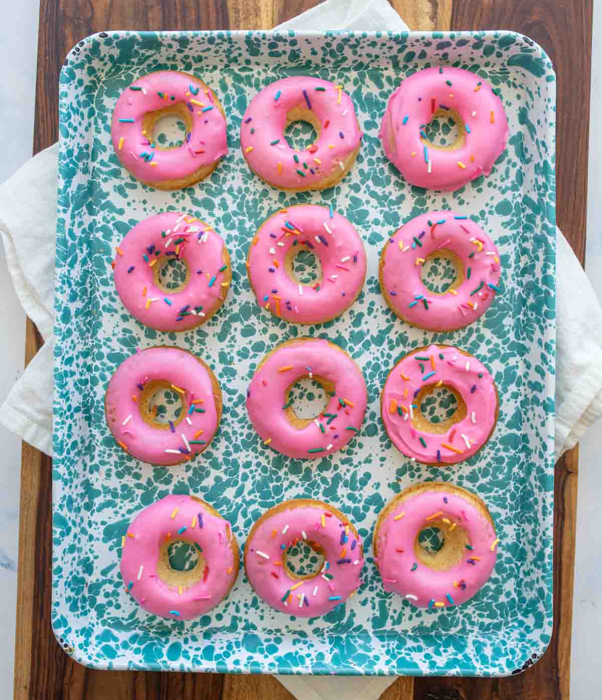 pink iced circle donuts with rainbow sprinkles