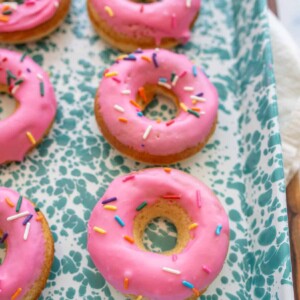 pink iced circle donuts with rainbow sprinkles