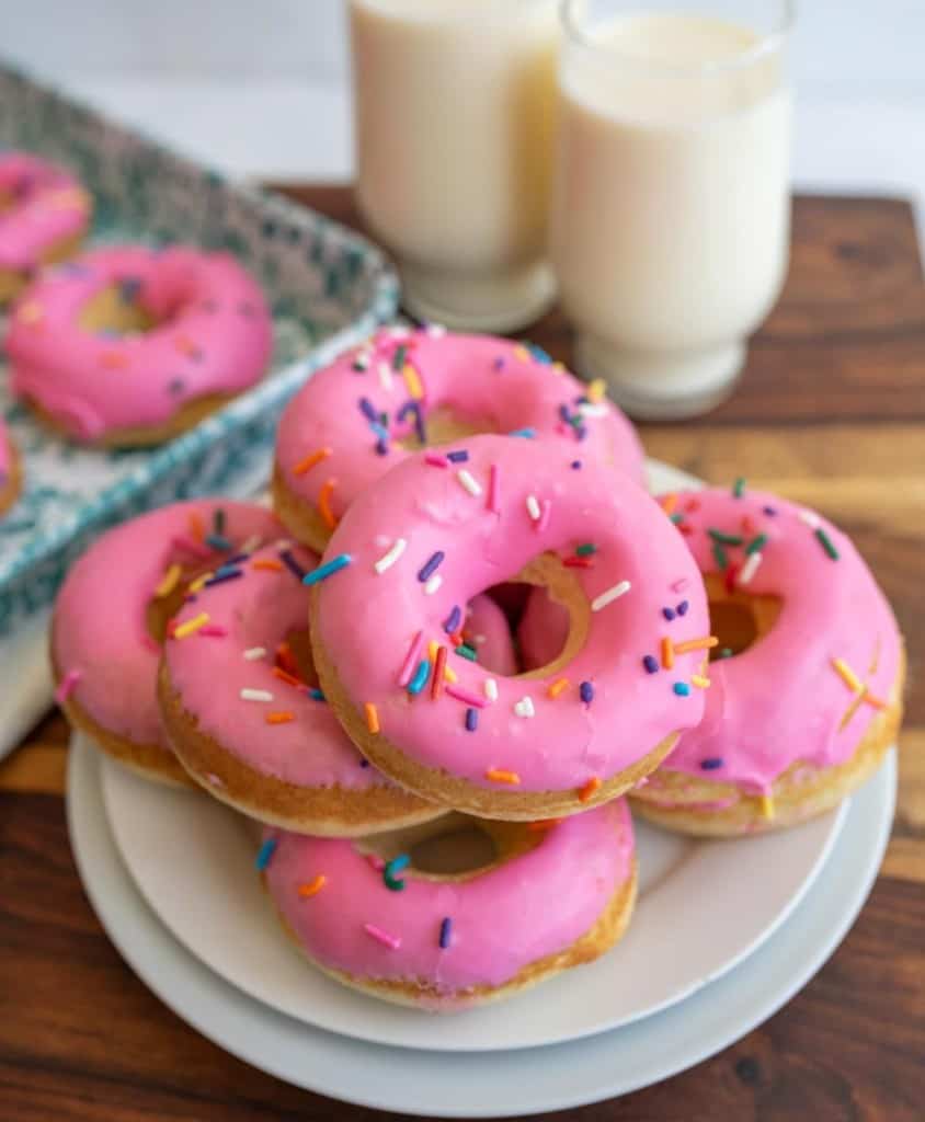 pink iced circle donuts with rainbow sprinkles