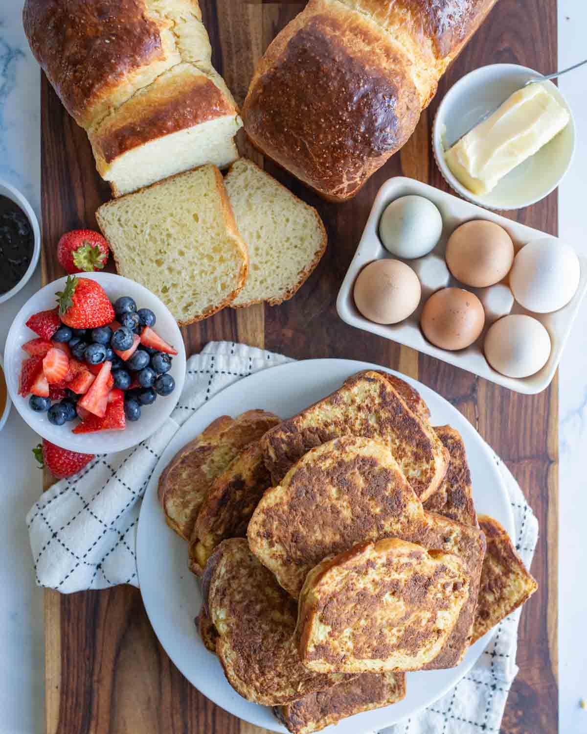 stack of thick brioche french toast slices on a white plate