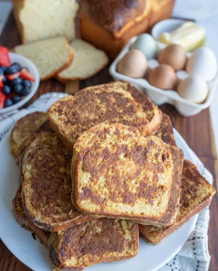 stack of thick brioche french toast slices on a white plate