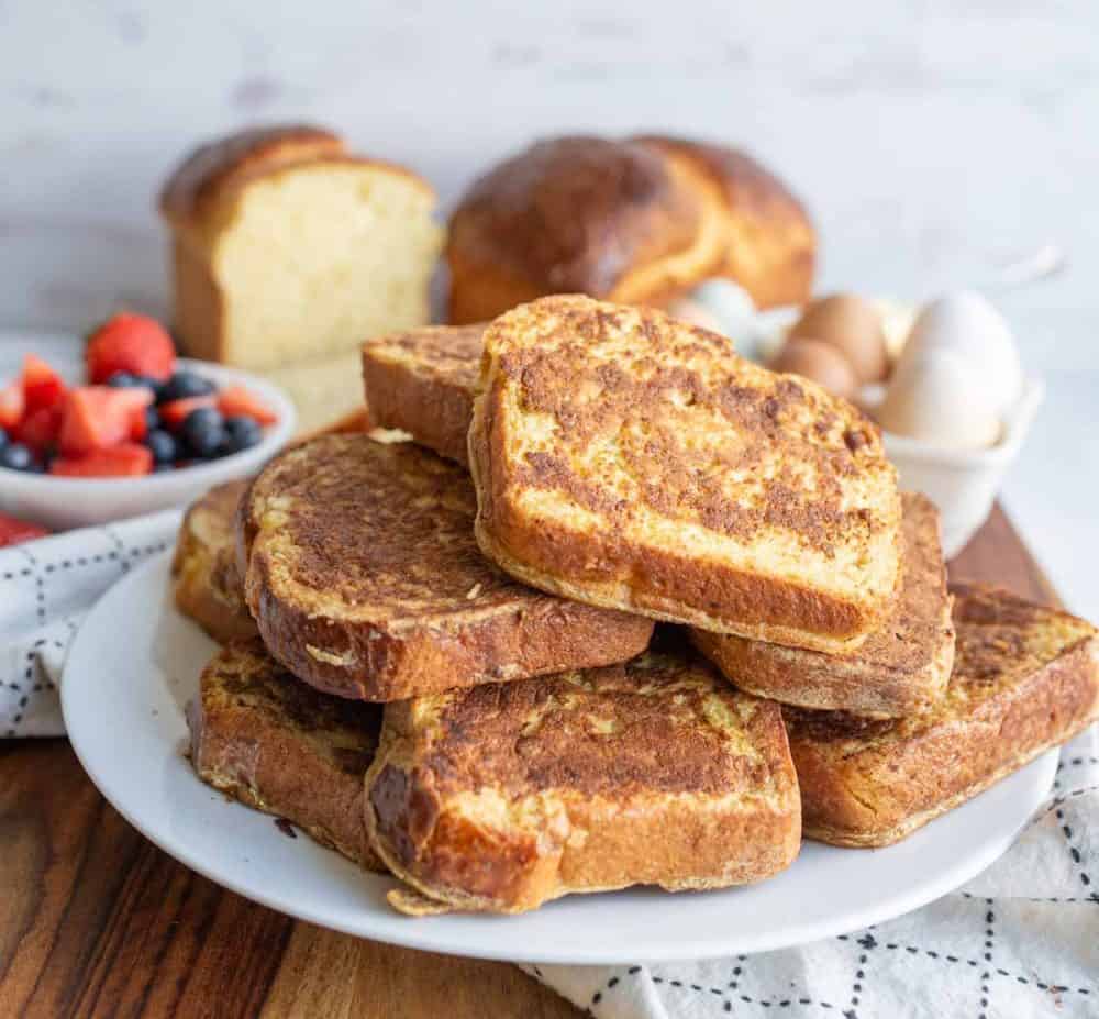 stack of thick brioche french toast slices on a white plate