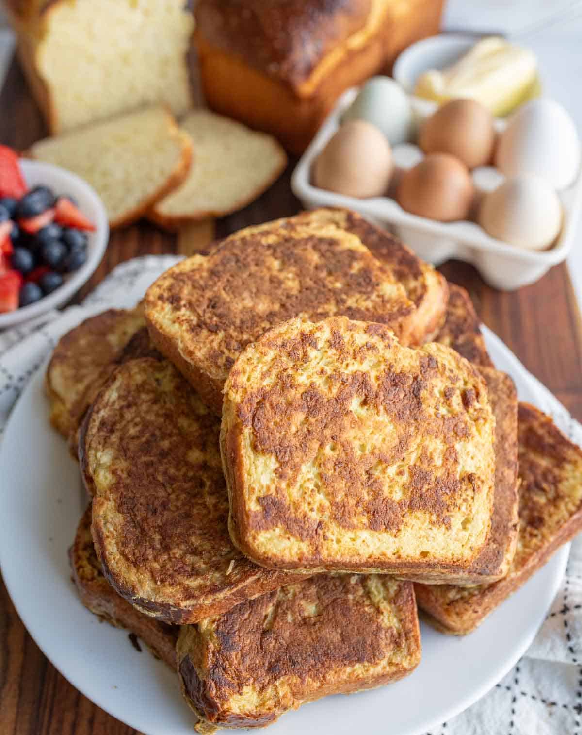 stack of thick brioche french toast slices on a white plate