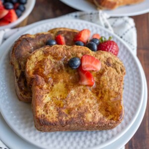 syrup over thick sliced brioche french toast with berries on top